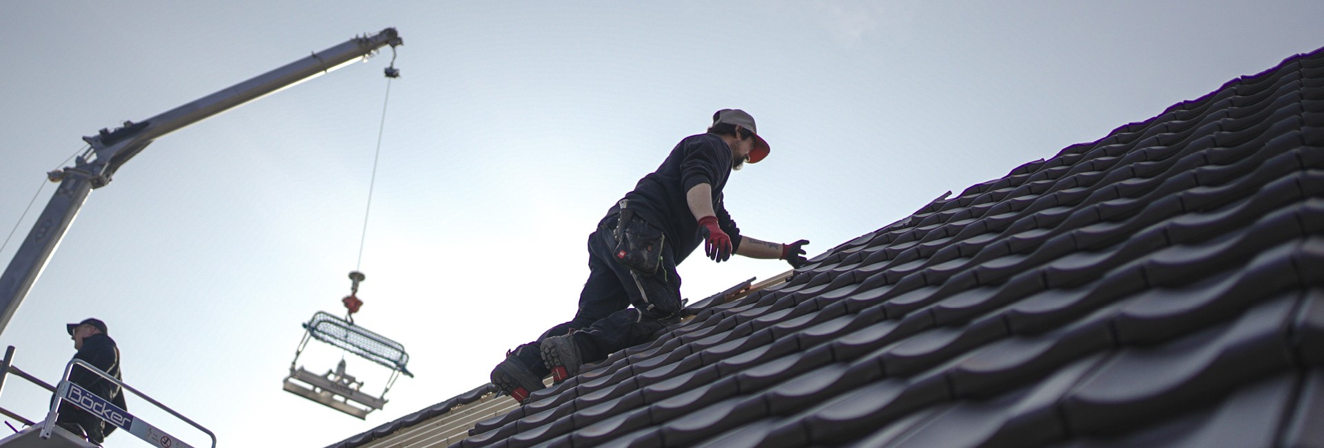 Dachdecker bei der Arbeit auf einem Steildach